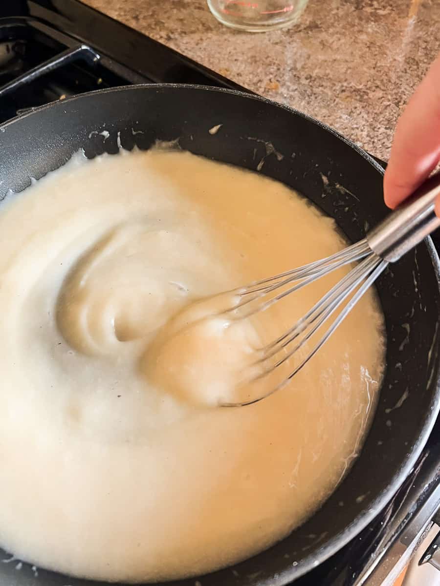 Cheesy potatoes rue making in saucepan