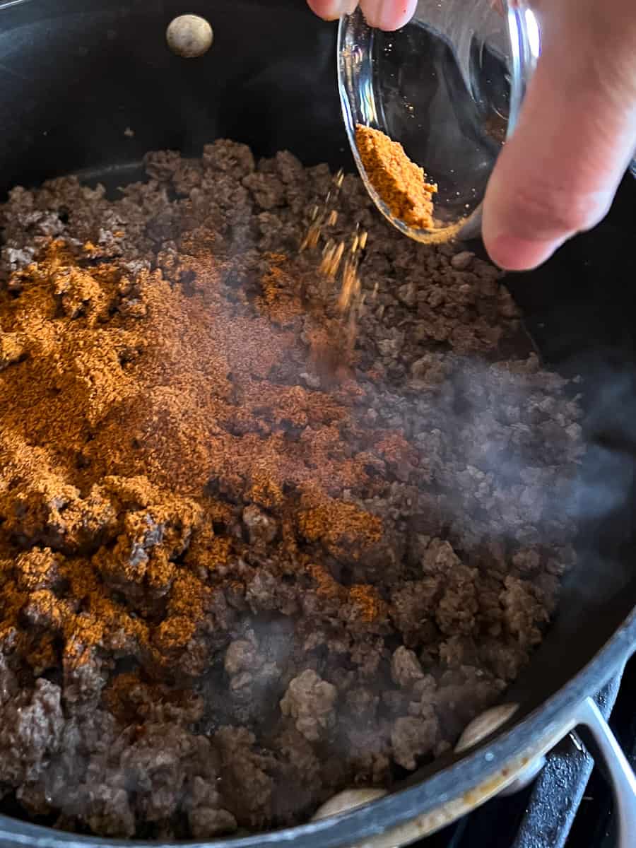 seasoning the ground beef with taco seasoning