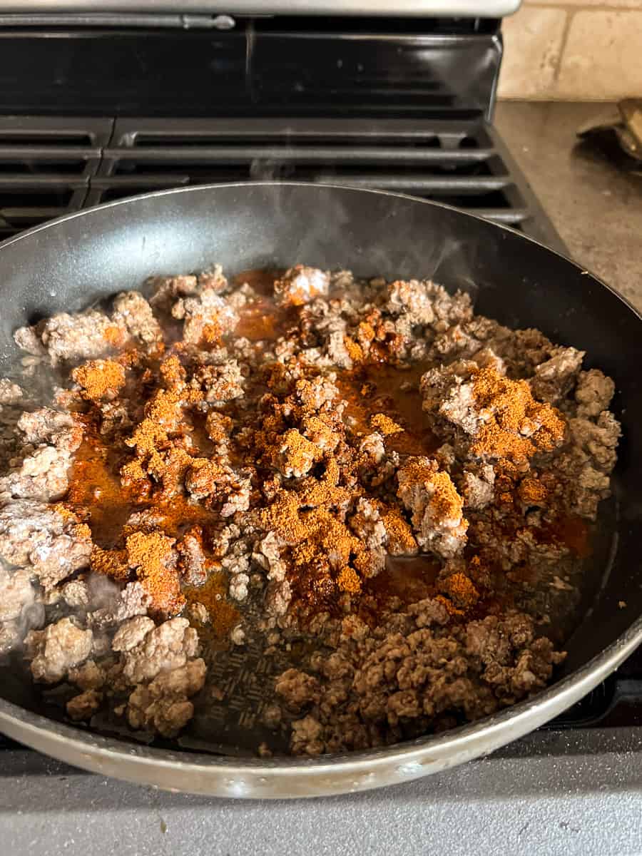 cooked ground beef in skillet with taco seasoning.