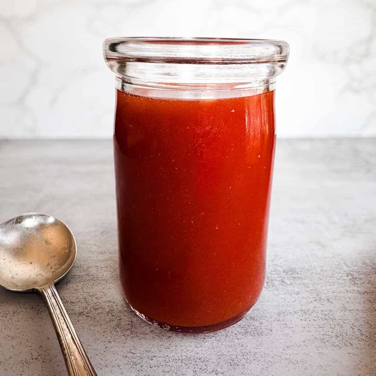 glass jar filled with western dressing and a serving spoon.