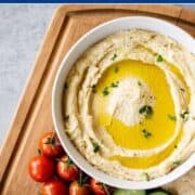 Bowl of creamy low FODMAP hummus topped with garlic oil.