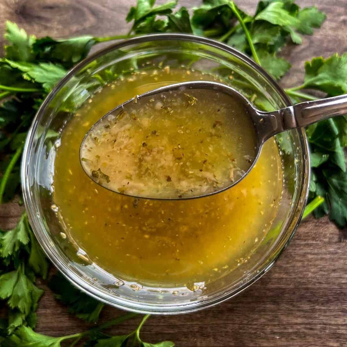 greek dressing in a bowl with spoon.
