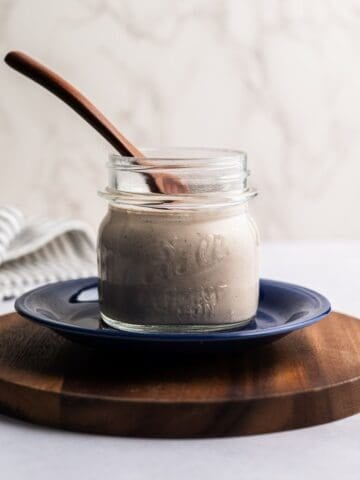 mason jar filled with mexican ranch dressing with a wooden spoon.