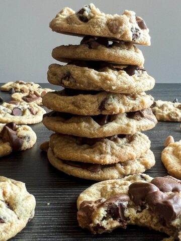 stack of cookies with one in the front with a bite taken out of it.