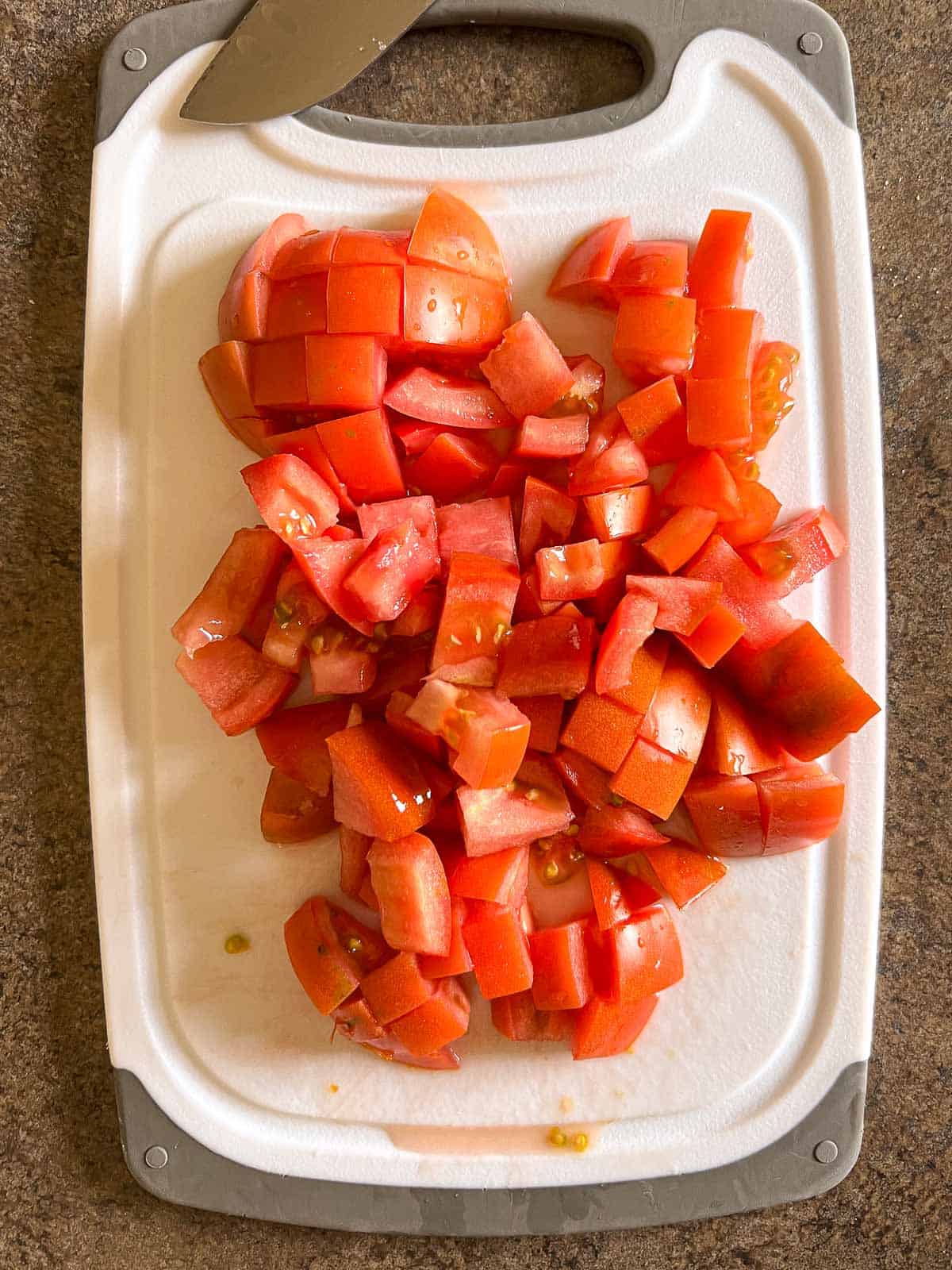 diced tomato on a cutting board.