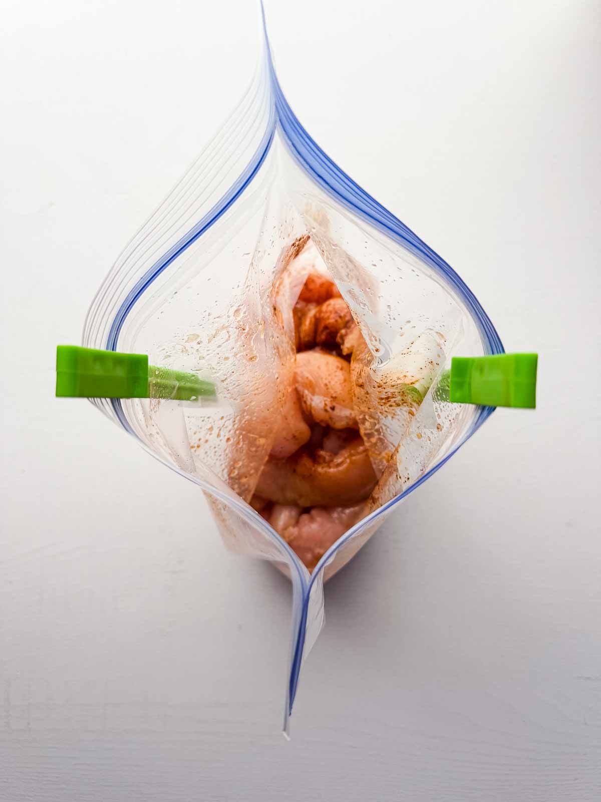 bag holder holding a ziploc bag with chicken marinade ingredients inside.