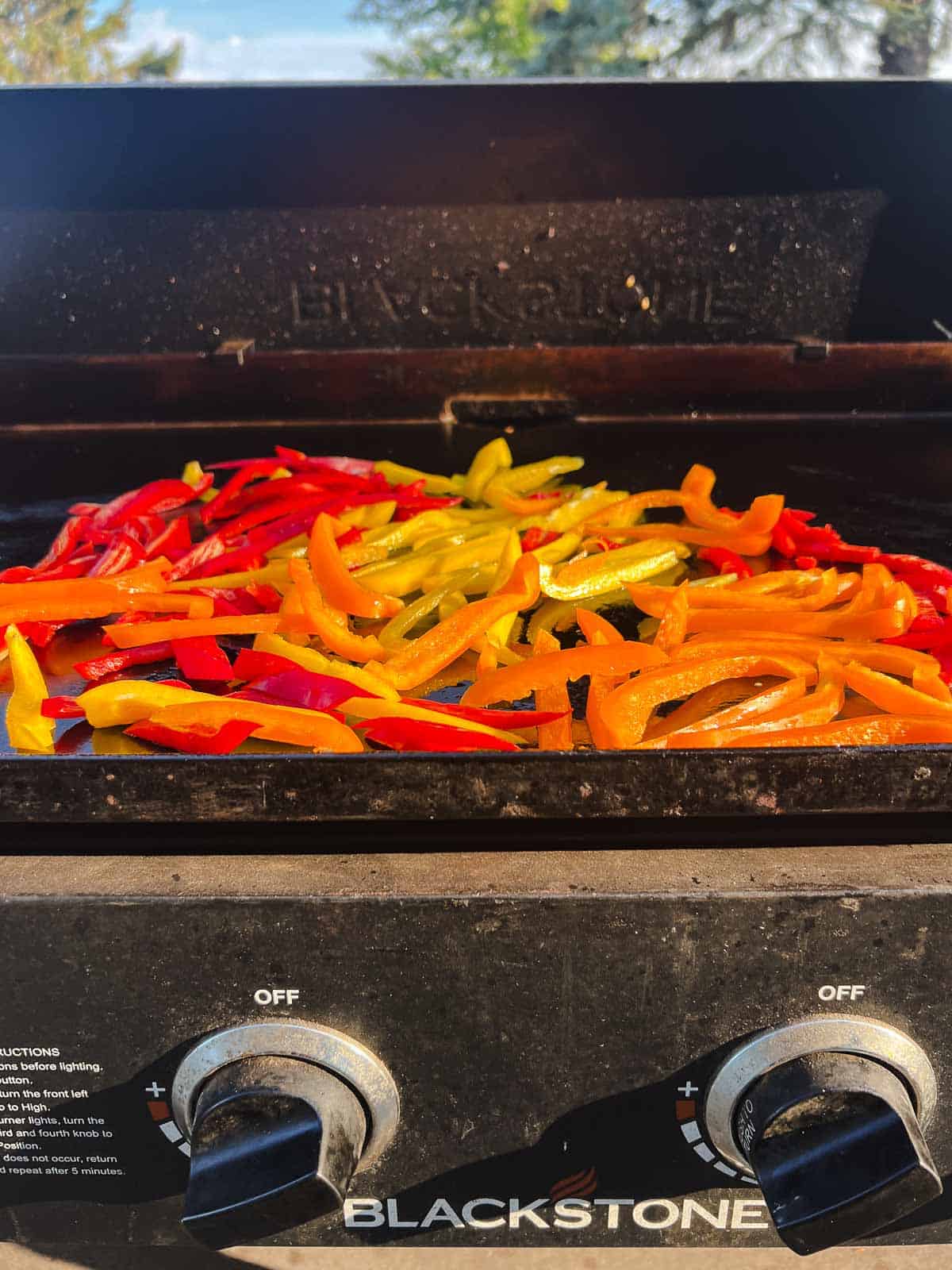 strips of bell peppers on a blackstone.