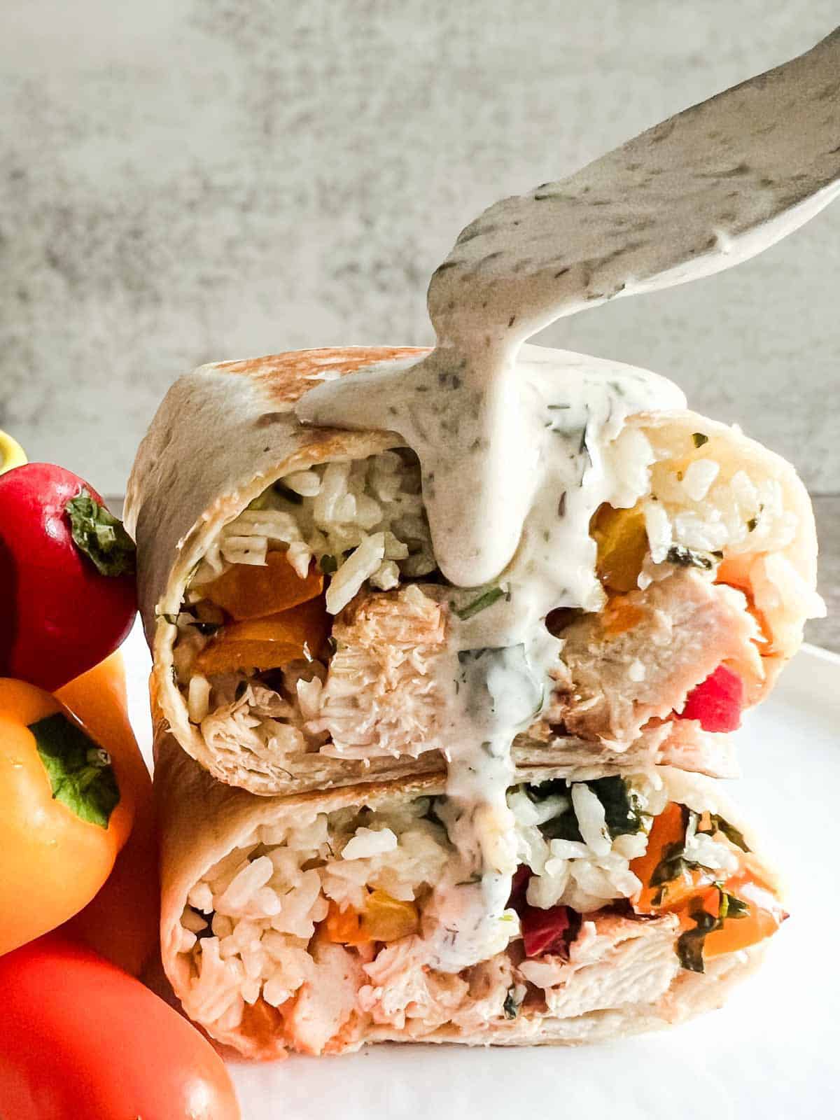 ranch dripping over a chicken burrito cut in half and stacked.