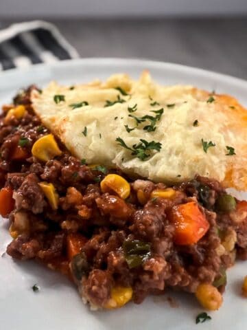 a piece of shepherd's pie on a white plate.