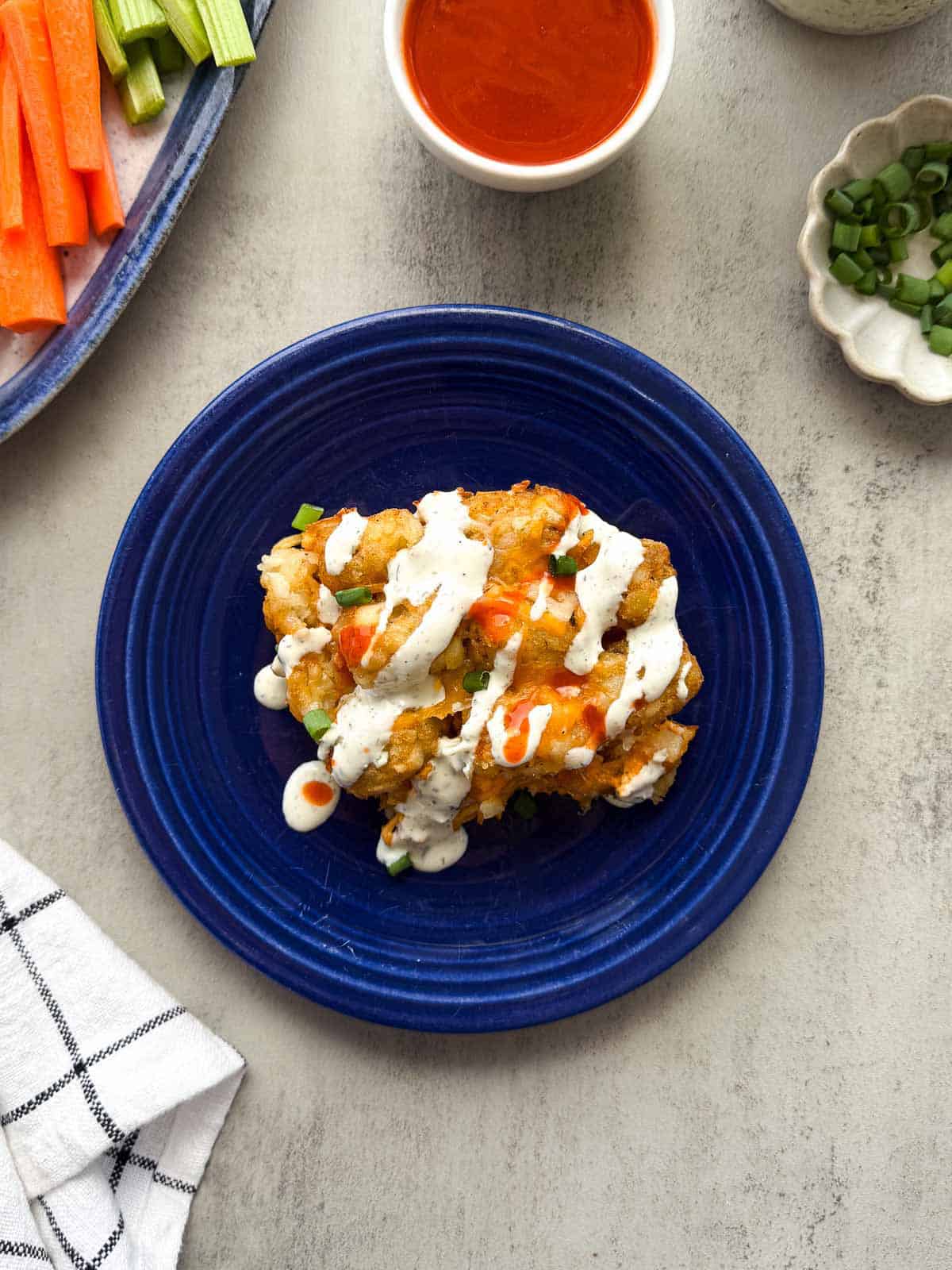 plate of buffalo chicken casserole drizzled with ranch dressing and buffalo sauce.