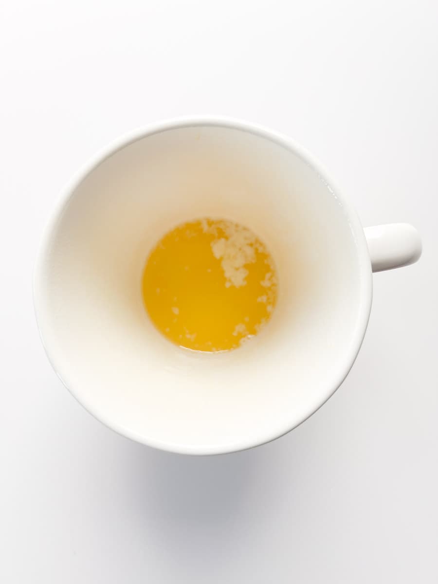white mug filled with melted butter.