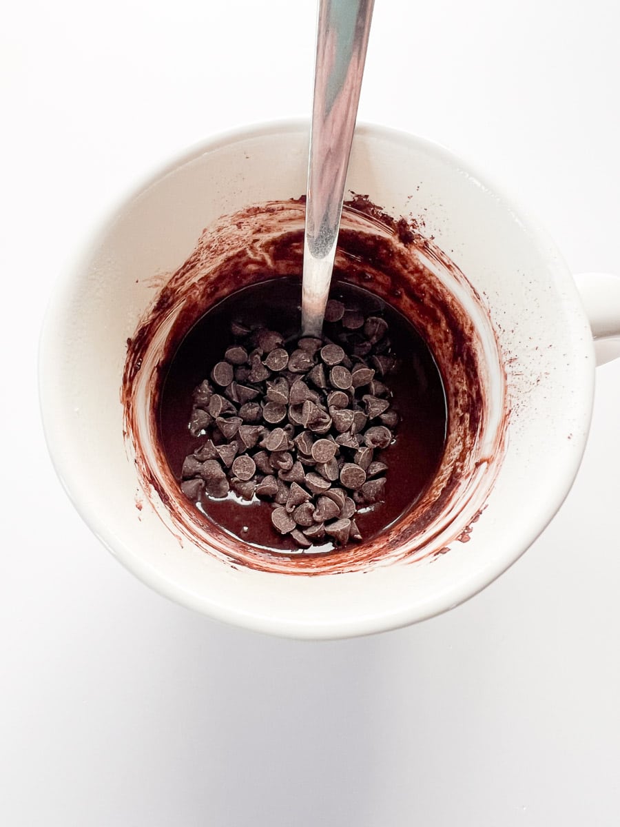 chocolate chips on top of a white mug.