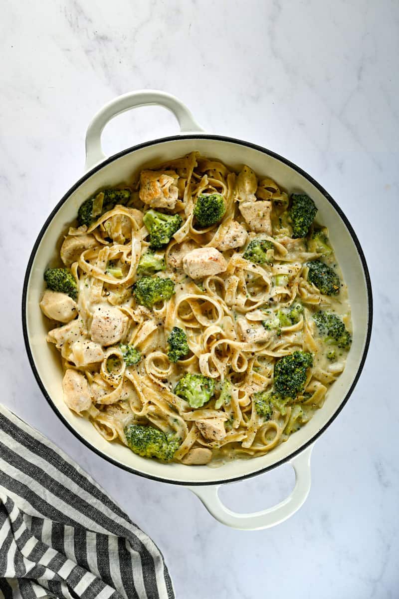 white serving dish full of chicken broccoli alfredo.