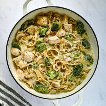 white serving dish of chicken alfredo and a napkin.