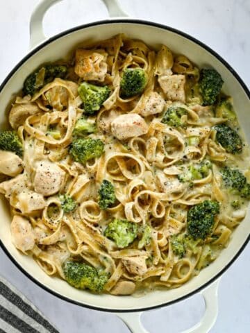 white serving dish of chicken alfredo and a napkin.