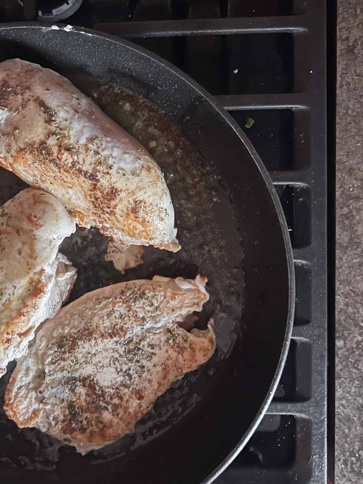 golden brown chicken breasts in a skillet. 