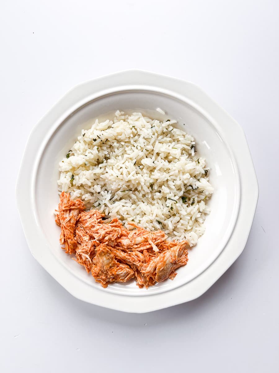 white bowl with cilantro lime rice and shredded buffalo chicken.