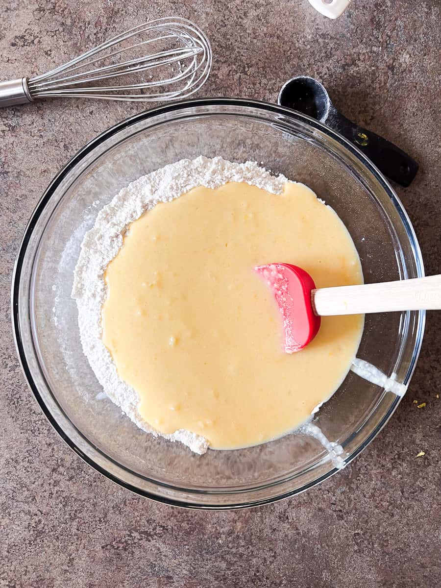 dry and wet ingredients in a large glass bowl with a spatula. 