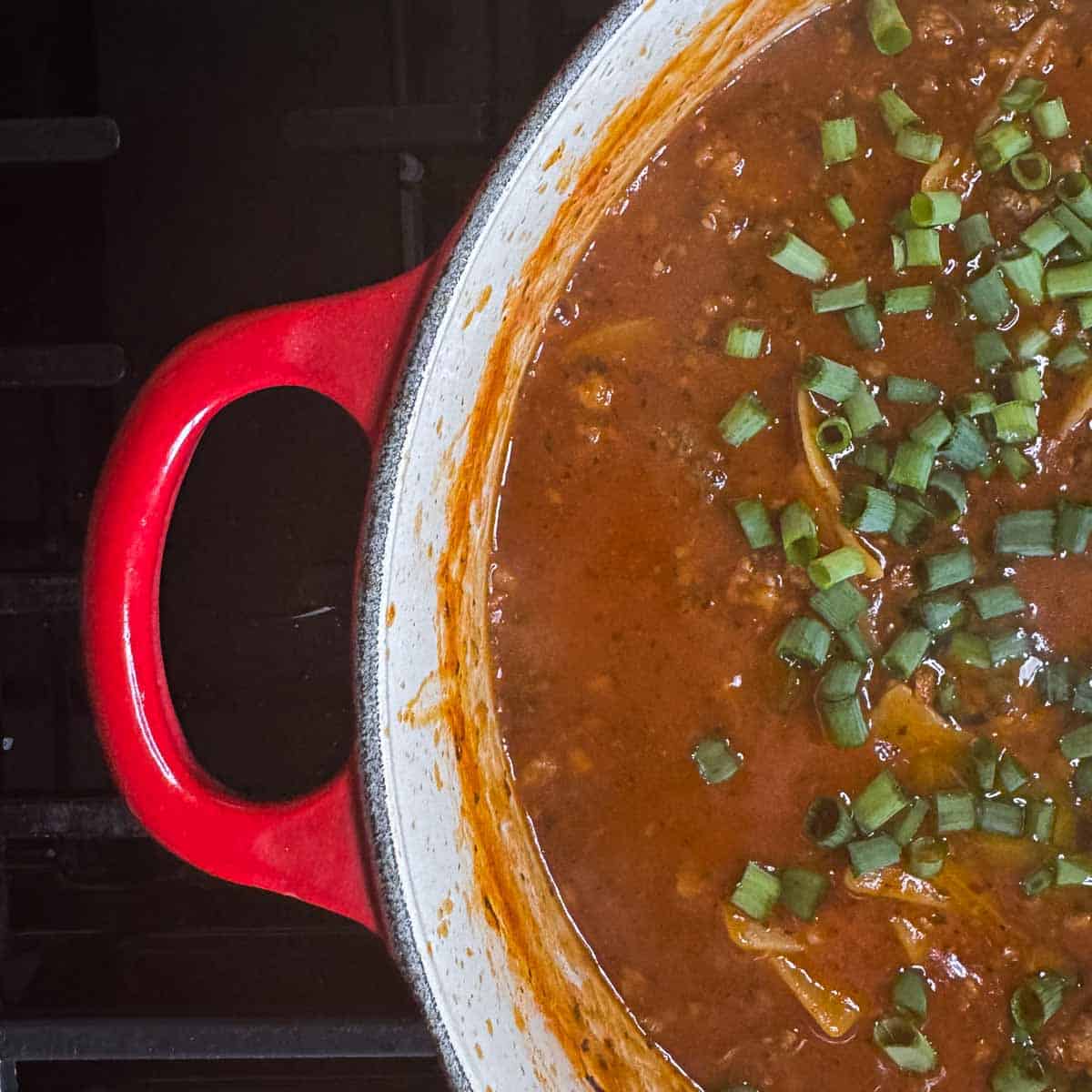 finished lasagna soup with chopped green onions and garlic oil added.