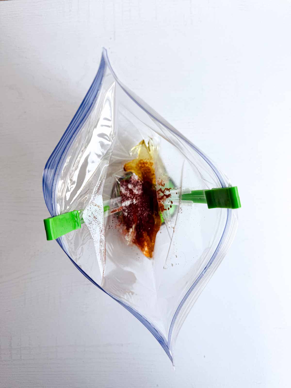 zip top bag being held by a bag holder with marinade ingredients inside. 