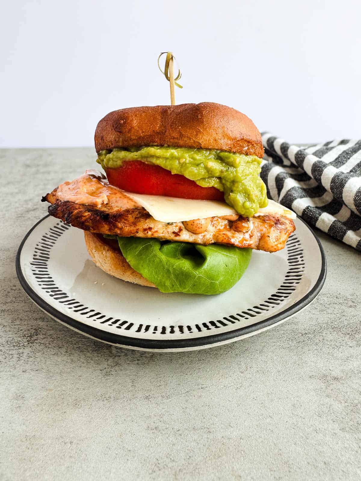 grilled chicken stacked with lettuce, chipotle mayo, tomato, cheese and guac on a gluten free hamburger bun. 