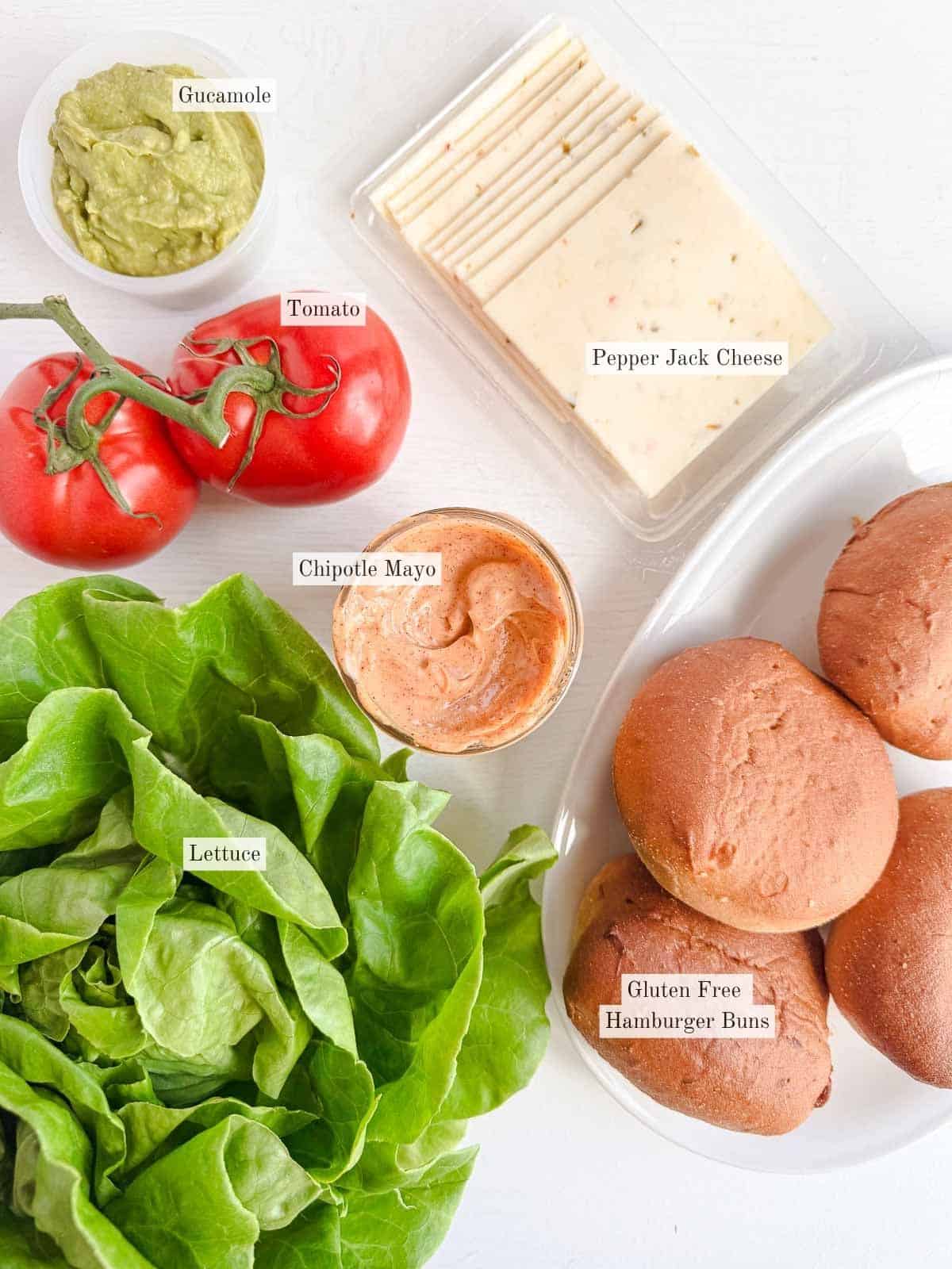 The ingredients for a chicken sandwich on a white table.