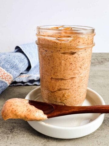 mason jar full of chipotle mayo with a small wooden spoon alongside it.