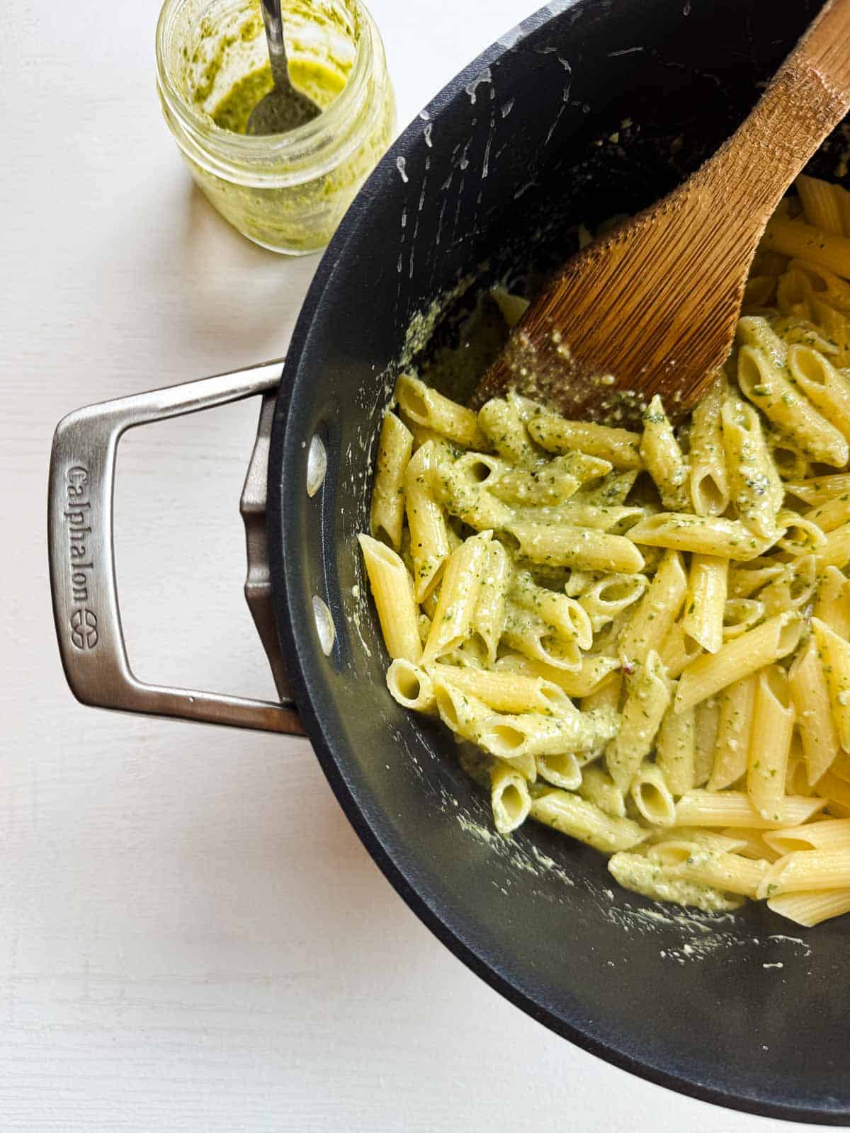 pesto sauce with penne noodles in a black pot.