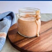 Glass jar filled with homemade low FODMAP Thousand Island dressing on a wood board.