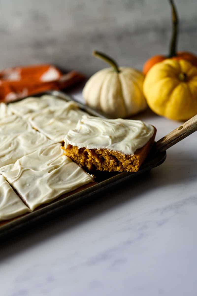 one pumpkin bar being removed from the jelly roll pan.