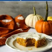gluten free pumpkin bar with cream cheese frosting with a bite taken out of it on a plate.