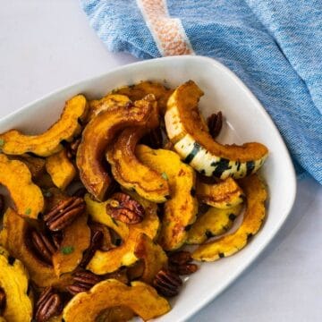 crescent shaped roasted delicata squash on a platter.