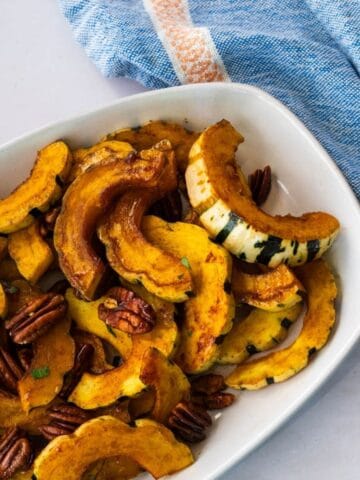 crescent shaped roasted delicata squash on a platter.