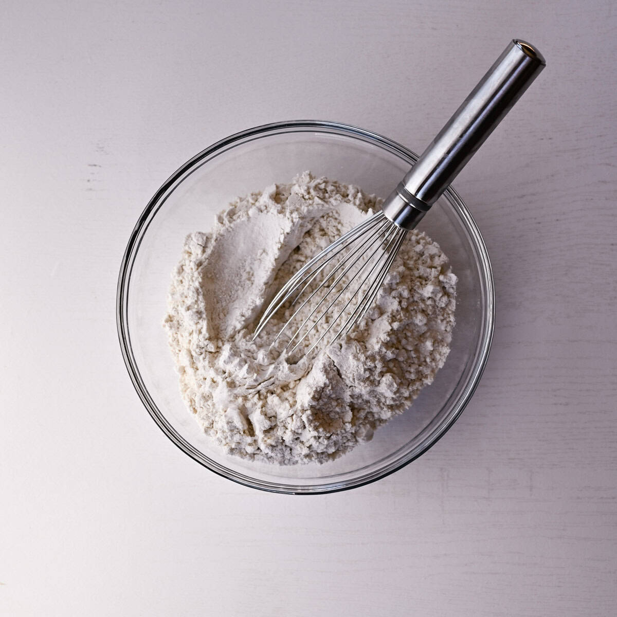 dry ingredients in a glass bowl with a whisk.