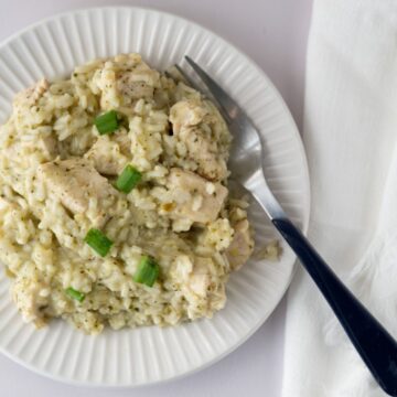 plate of salsa verde chicken and rice with a fork and napkin.