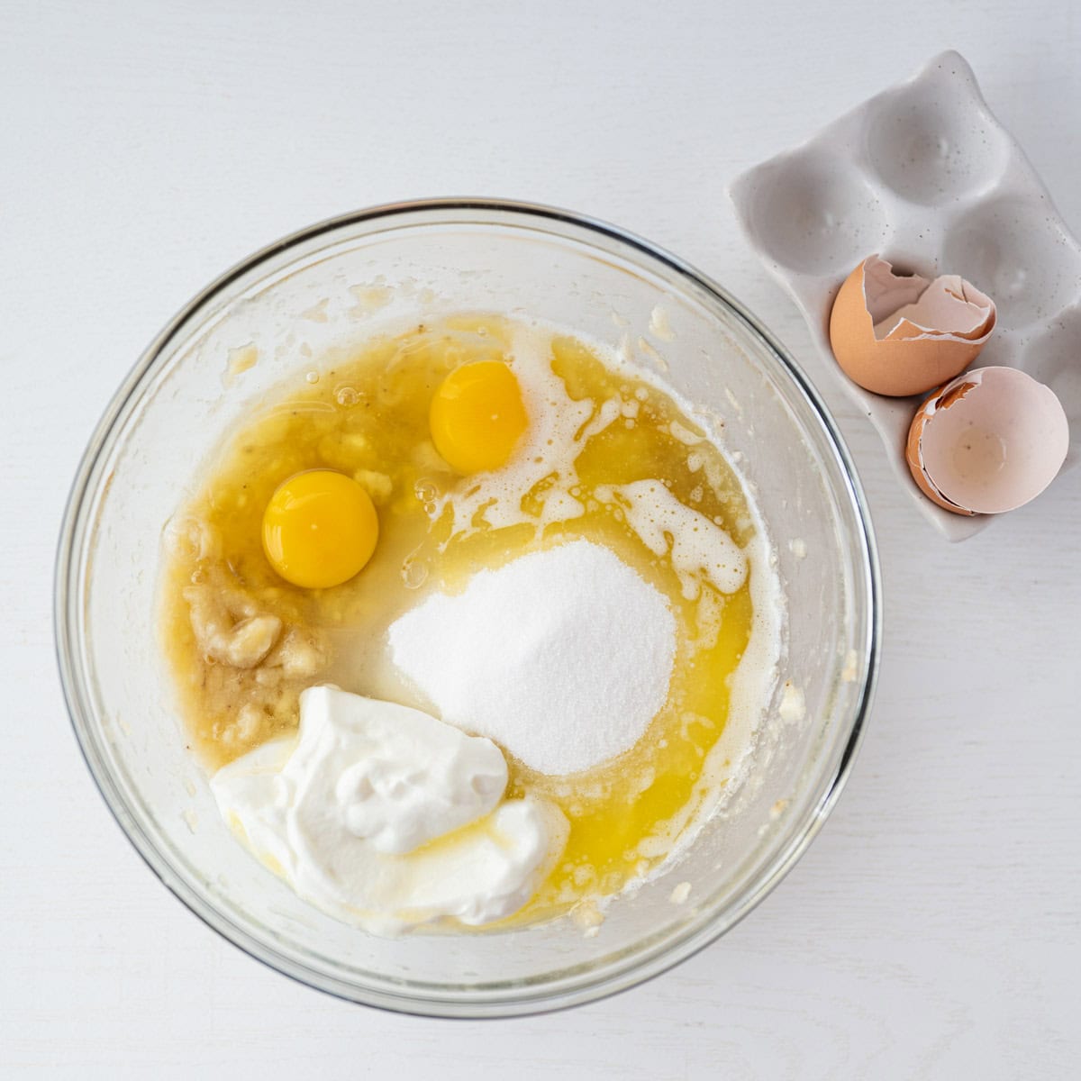 wet ingredients added to the mixing bowl for banana bread.