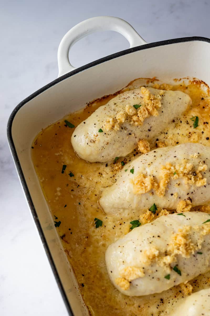 baked chicken caesar in a white casserole dish.
