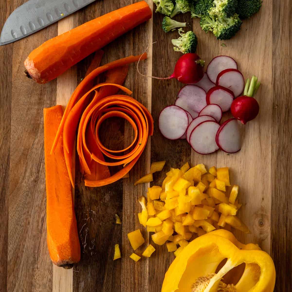 cut up broccoli, bell peppers, sliced radishes and carrot ribbons.