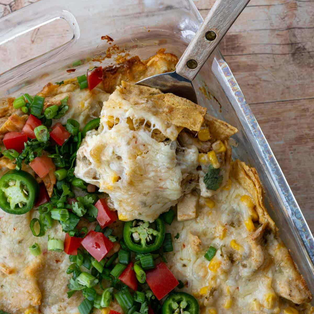baked and topped chicken casserole with a wooden serving spatula.