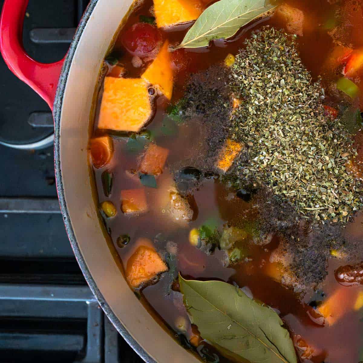 spices added to the red dutch oven before simmering.