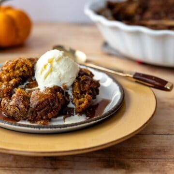 serving of pumpkin cake on a plate with a scoop of ice cream.