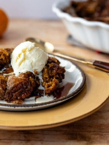 serving of pumpkin cake on a plate with a scoop of ice cream.