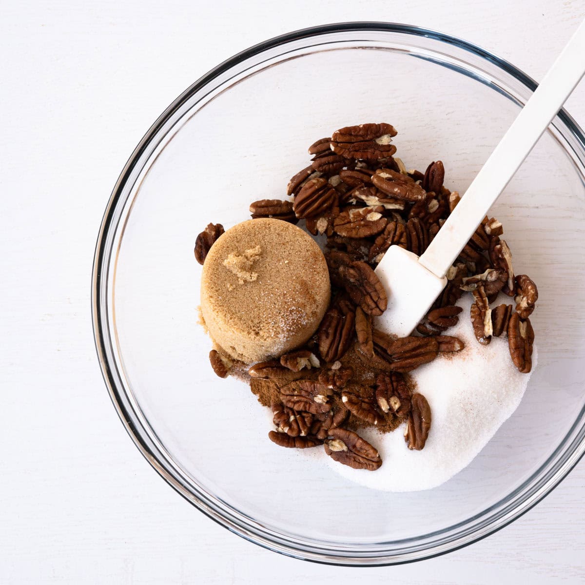 topping ingredients in a glass bowl with a white spatula.