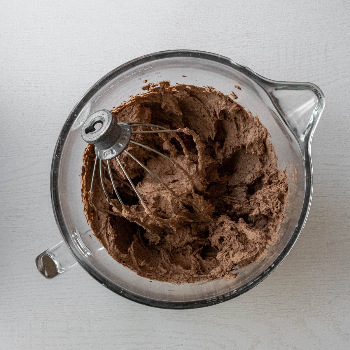 mixing bowl full of chocolate pudding mousse like with a whisk.