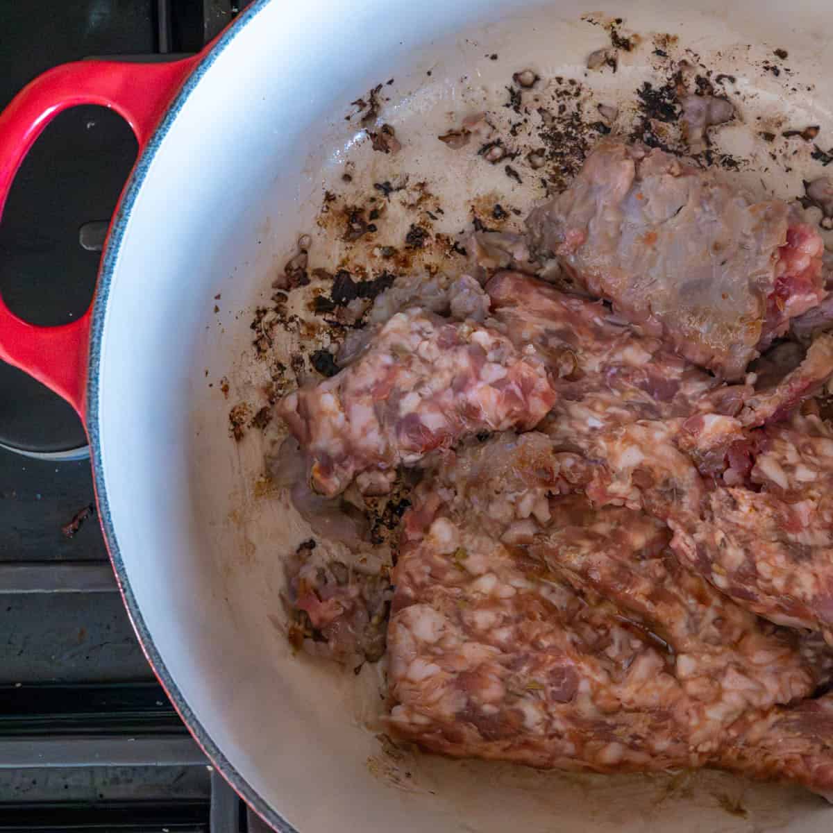 brown the italian sausage in a red dutch oven on the stovetop.