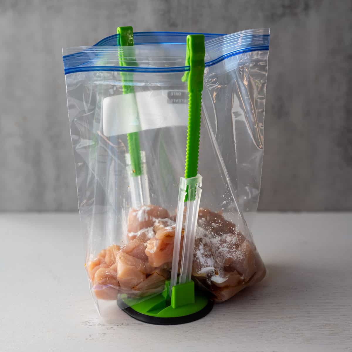zip top bag holder with diced chicken inside with cornstarch, rice vinegar and soy sauce.