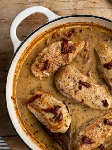 large pan with finished marry me chicken on a wooden table.