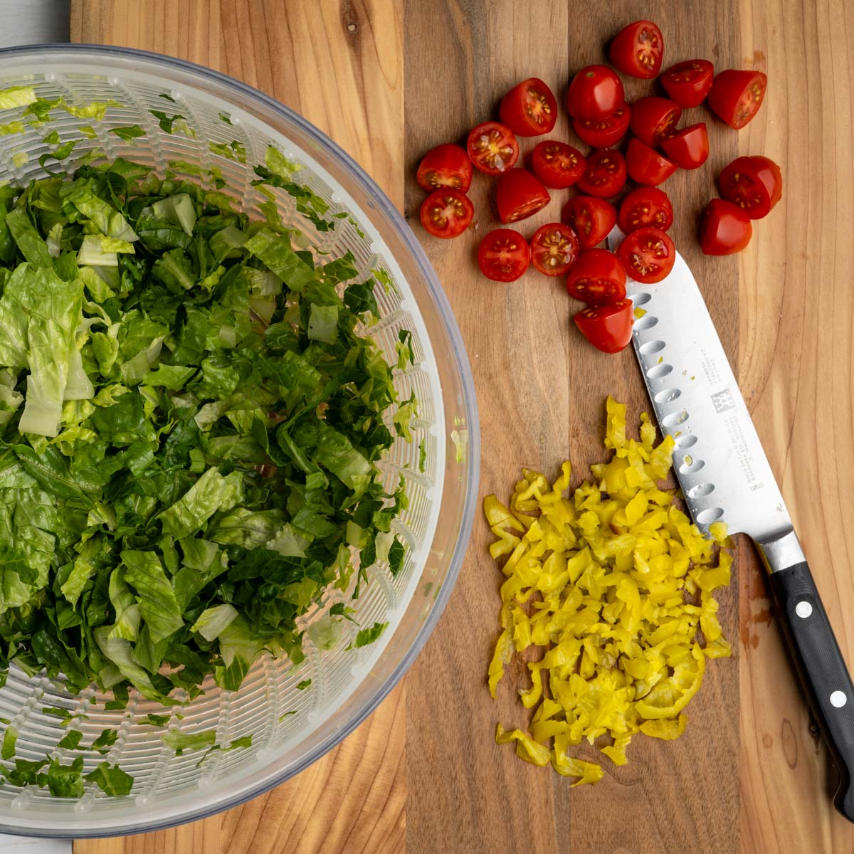 chopped vegetables on a wooden board with a knife.