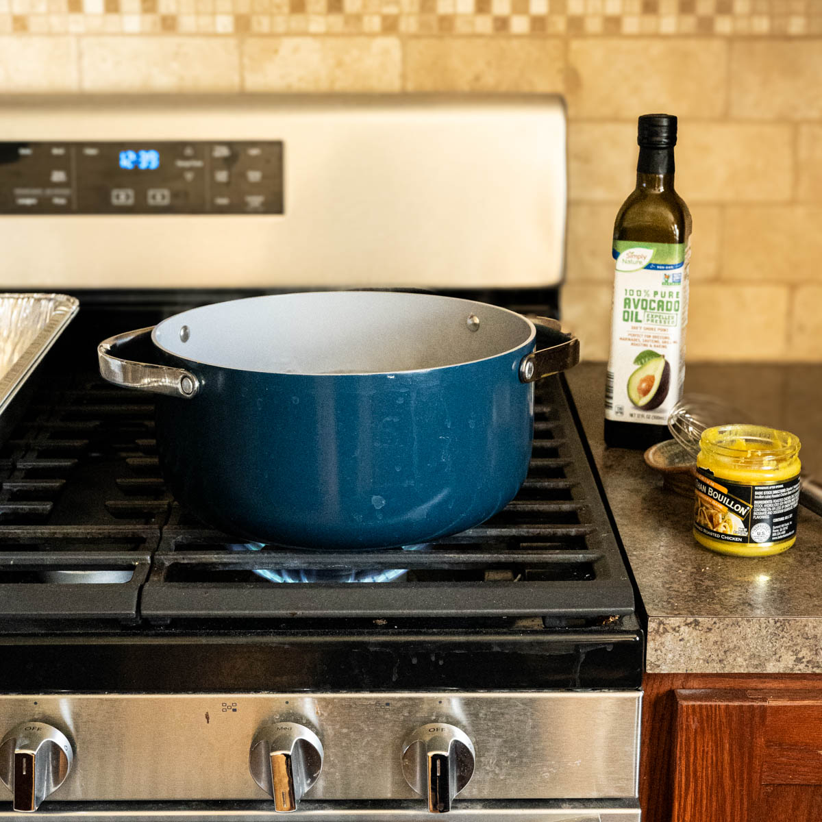 large pot next to a bottle of avocado oil and a jar of better than chicken boullion.