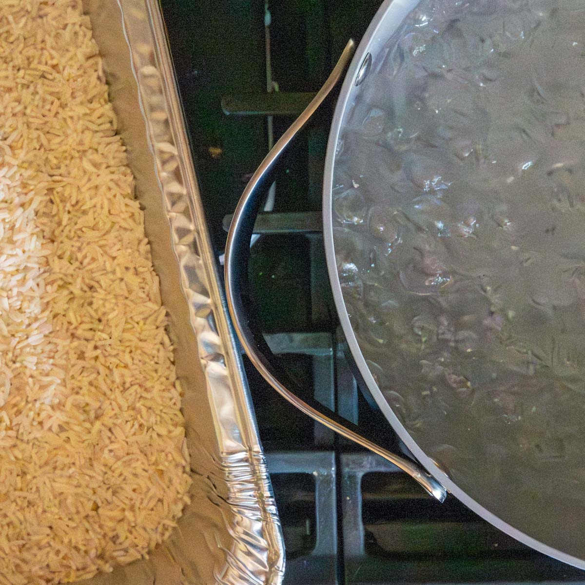 boiling water in a large pot next to a pan of white rice before cooking.